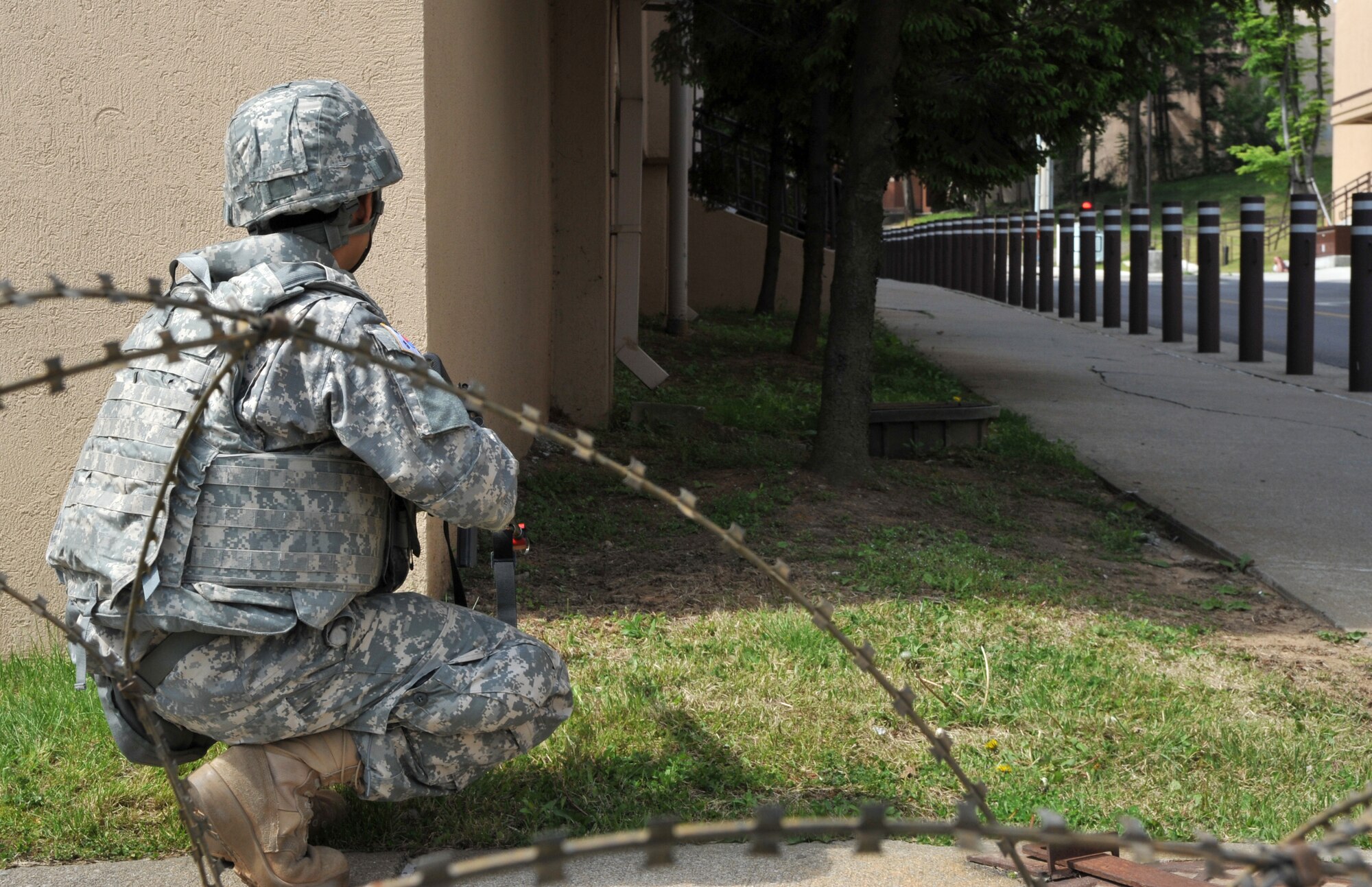 Republic of Korea army Cpl. Sang Woo Kang waits for mock opposition forces members to give away their position during Operational Readiness Exercise Beverly Bulldog 14-02 at Osan Air Base, ROK, May 7, 2014. Role players ambushed Soldiers from the U.S. and ROK Armies and engaged in a mock firefight in attempt to gain control of the area around the 3rd Battlefield Coordination Detachment Headquarters. (U.S. Air Force photo/Airman 1st Class Ashley J. Thum)
