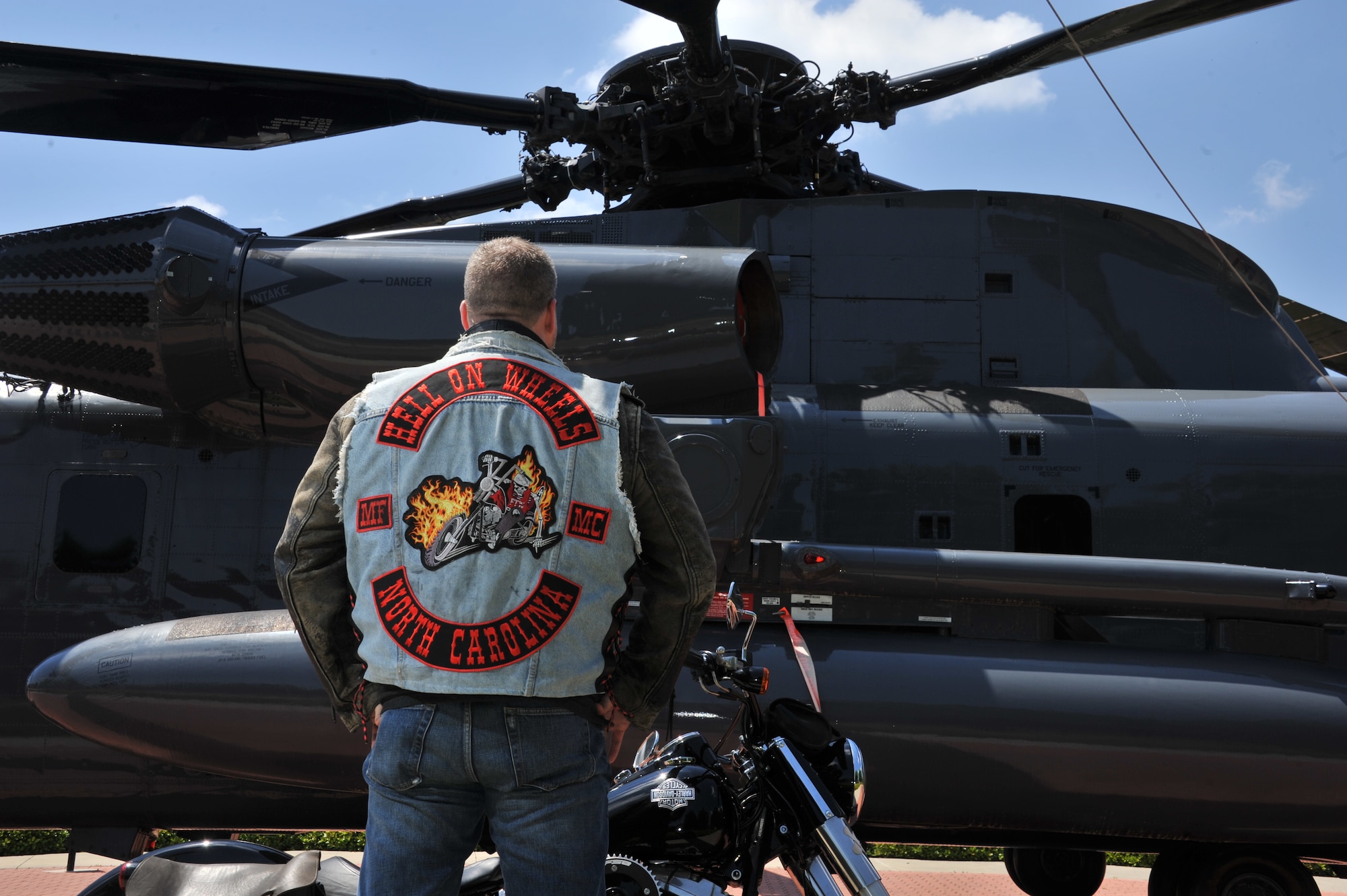 William Dulaney, professor of organizational communication at the Air Force Culture and Language Center, and a faculty member of the Air University Air War College, looks at an HH-53 Super Jolly Green Giant static display on his Harley, at Maxwell Air Force Base. Dulaney spent his military career in a variety of positions, including the Special Forces, and is a member of the Biker culture and a member of a motorcycle club. . He is getting ready to deploy for his third one-year tour in Afghanistan as an advisor to the U.S. military forces there on a mission to support the transition of operations and leadership to the Afghan government. (U.S. Air Force photo by Staff Sgt. Gregory Brook) 