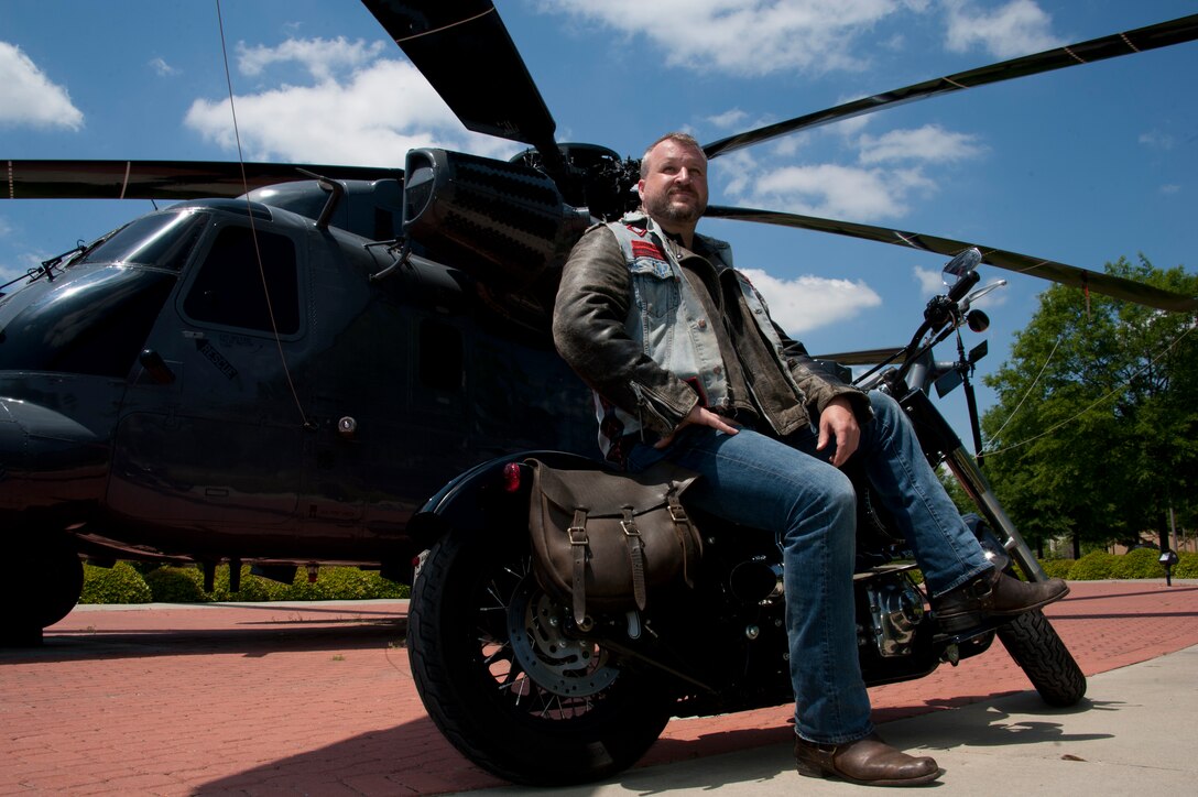 William Dulaney, professor of organizational communication at the Air Force Culture and Language Center, and a faculty member of the Air University Air War College, poses in front of an HH-53 Super Jolly Green Giant static display on his Harley, at Maxwell Air Force Base. Dulaney, a former missiles troop and later a Special Forces airman, is one of the world’s foremost authorities on the biker subculture and advises the Air Force on intercultural communication. He is getting ready to deploy for his third one-year tour in Afghanistan as an advisor to the U.S. military forces there on a mission to support the transition of operations and leadership to the Afghan government. (U.S. Air Force photo by Staff Sgt. Gregory Brook) 