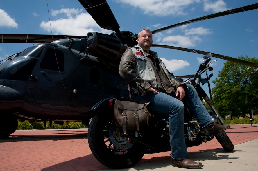 William Dulaney, professor of organizational communication at the Air Force Culture and Language Center, and a faculty member of the Air University Air War College, poses in front of an HH-53 Super Jolly Green Giant static display on his Harley, at Maxwell Air Force Base. Dulaney, a former missiles troop and later a Special Forces airman, is one of the world’s foremost authorities on the biker subculture and advises the Air Force on intercultural communication. He is getting ready to deploy for his third one-year tour in Afghanistan as an advisor to the U.S. military forces there on a mission to support the transition of operations and leadership to the Afghan government. (U.S. Air Force photo by Staff Sgt. Gregory Brook) 