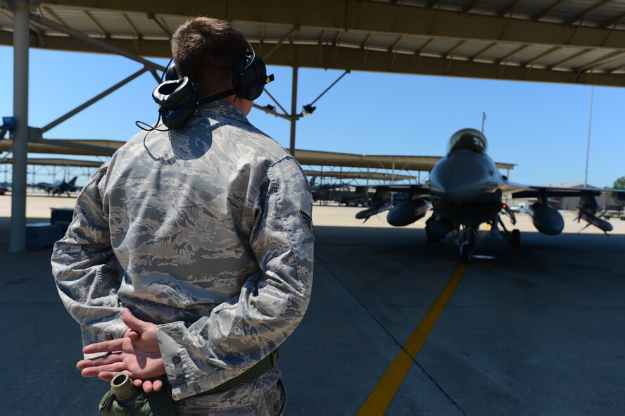 U.S. Air Force Senior Airman Ethan Edmisten, 20th Aircraft Maintenance Squadron assistant dedicated tactical aircraft maintainer assigned to the 55th Aircraft Maintenance Unit, waits to release an F-16CJ Fighting Falcon before it taxis out of a sun shade during Operational Readiness Exercise Weasel Victory 14-06 at Shaw Air Force Base, S.C., May 5, 2014. Edmisten spent more than an hour prepping the F-16CJ Fighting Falcon, ensuring the jet was prepared to fly. (U.S. Air Force photo by Airman 1st Class Jensen Stidham/Released)