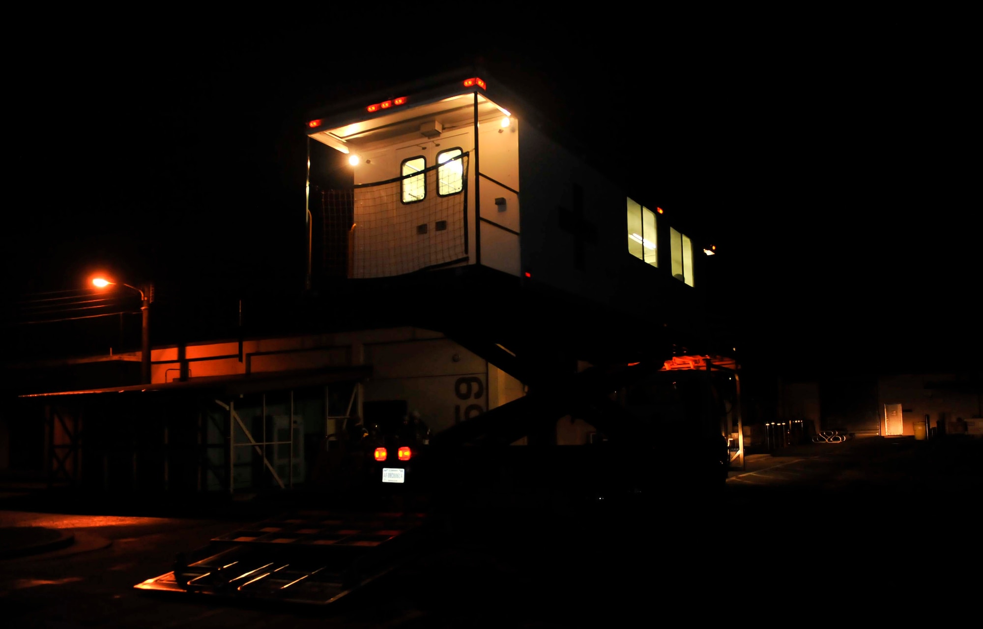 The high-deck patient loading platform vehicle is raised to simulate it being elevated to transfer patients to an aircraft May 8 near the emergency room during a simulated patient transfer Osan Air Base, Republic of Korea. The vehicle provides space to transfer up to six patients on NATO litters and 10 additional ambulatory patients. (U.S. Air Force photo by Senior Airman David Owsianka)