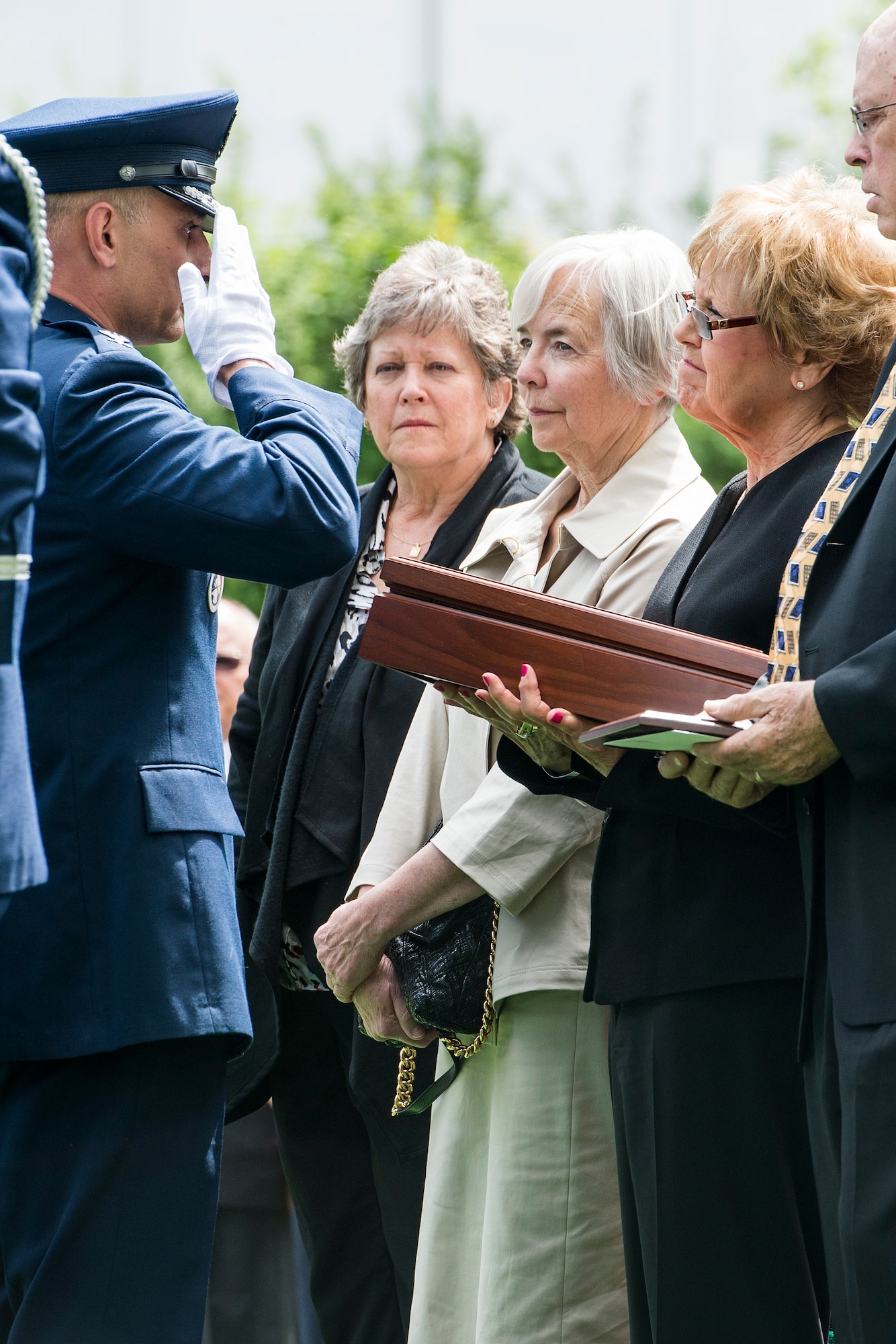 Col. Anthony Davit, 627th Air Base Group commander, salutes as he presents an encased flag to Sue Scott, sister of Air Force Capt. Douglas D. Ferguson May 2, 2014, in Lakewood, Wash. Ferguson's F-4D aircraft was shot down over Laos in 1969 and his remains were returned home after being missing for more than 44 years. (U.S. Air Force photo/Tech. Sgt. Sean Tobin)