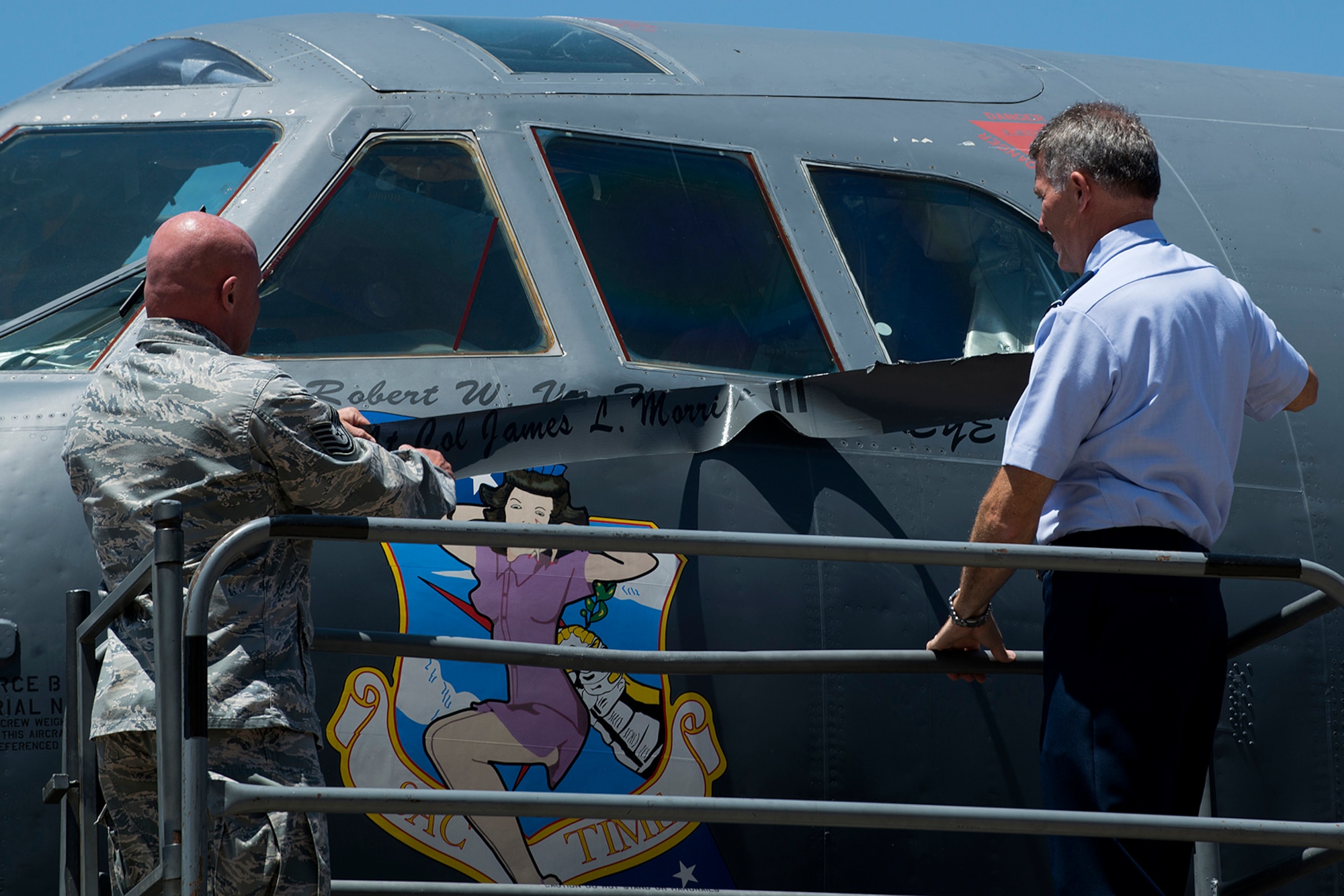 U.S. Air Force Tech. Sgt. Jessie Brouillette, 307th Aircraft Maintenance Squadron crew chief, and Lt. Col. Robert Van Hoy, 93rd Bomb Squadron (BS) commander, unveil Van Hoy's name written on the side of a B-52H Stratofortress, May 6, 2014, Barksdale Air Force Base, La. Van Hoy, the former Director of Operations for the 93rd BS, assumed command of the squadron during a Change of Command ceremony held earlier. (U.S. Air Force photo by Master Sgt. Greg Steele/Released)