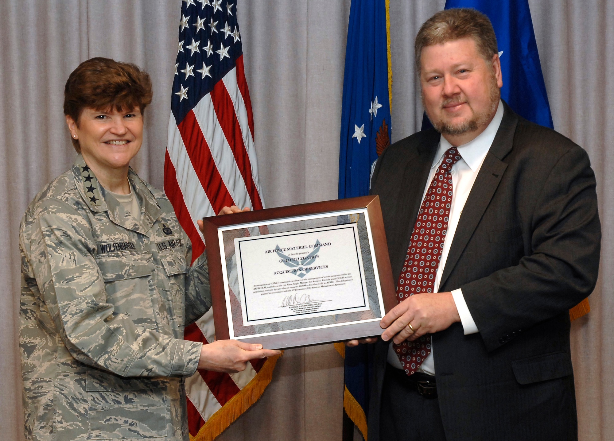 Randall Culpepper, Combat and Mission Support Program Executive Officer,
presents Gold Delegation Acquisition authority to Gen. Janet C. Wolfenbarger,
Air Force Materiel Command commander, on Feb. 13, 2014. Gold authority
recognizes the command's leadership commitment, knowledge of services,
continuous improvement, and overall success in managing AFPEO/CM services.
(Al Bright/U.S. Air Force photo)