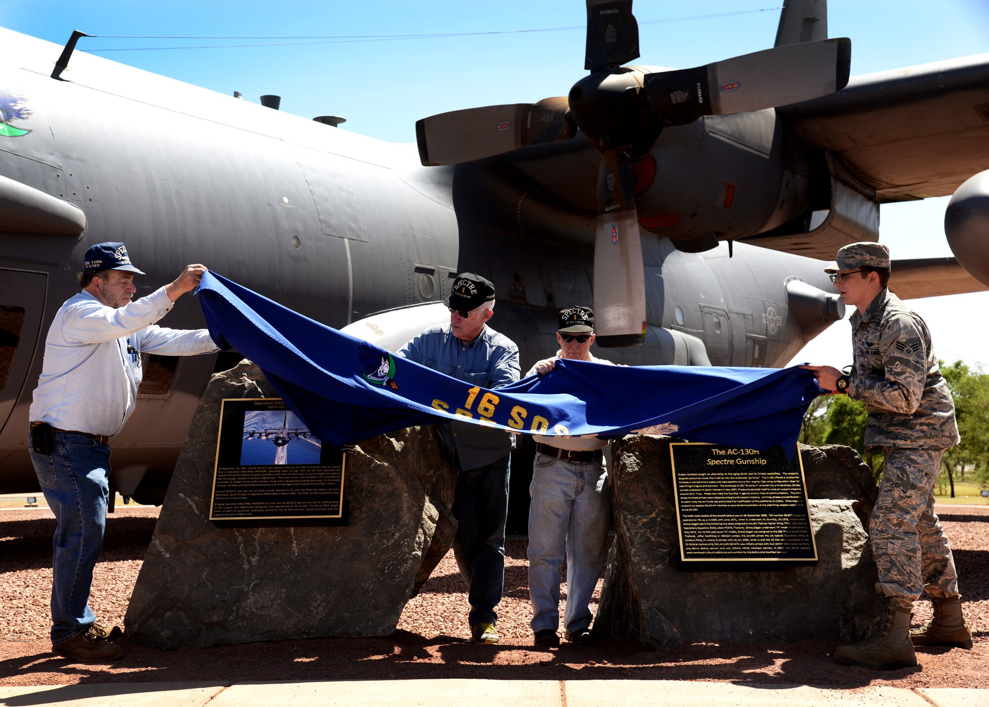 Air Force retirees, together with Senior Airman Anthony Dye, 16th Special Operations Squadron aerial gunner, unveil plaques commemorating the AC-130H Spectre gunship May 6, 2014 at Cannon Air Force Base, N.M. Larry Peterson, a veteran of the AC-130H and the Vietnam war, and Dye, represent the eldest and youngest Airmen who served on the Spectre. (U.S. Air Force Photo/Airman 1st Class Chip Slack)