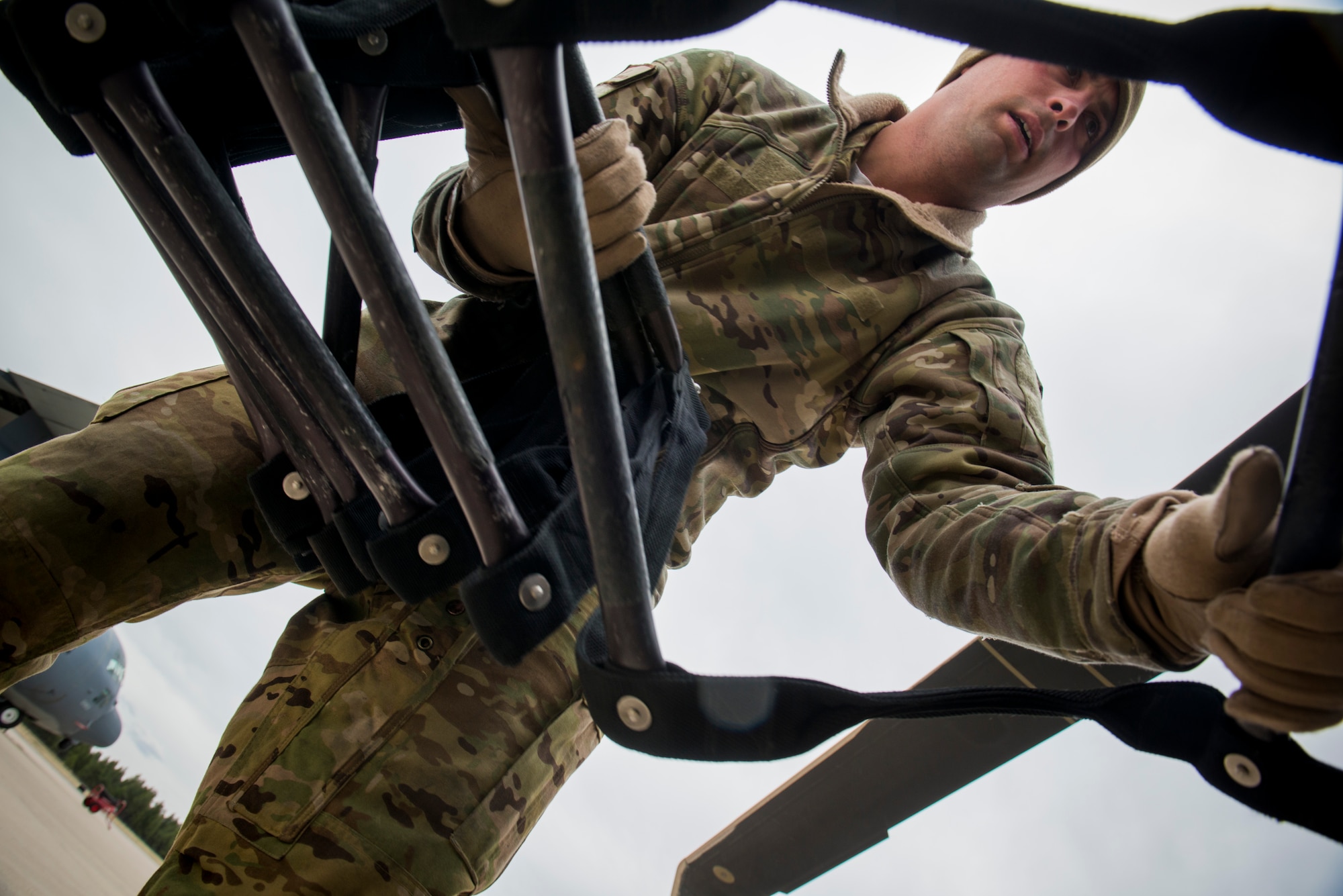 U.S. Air Force Senior Airman Christian Nault, 41st Rescue Squadron special missions aviator out of Moody Air Force Base, Ga., folds a rope ladder in preparation for flight on an HH-60G Pave Hawk May 6, 2014, at Flagstaff Pulliam Airport, Ariz. Nault is one of many Airmen from Moody conducting missions out of Flagstaff in part of Angel Thunder, a two-week exercise dedicated to personnel recovery training. (U.S. Air Force photo by Staff Sgt. Jamal D. Sutter/Released)    