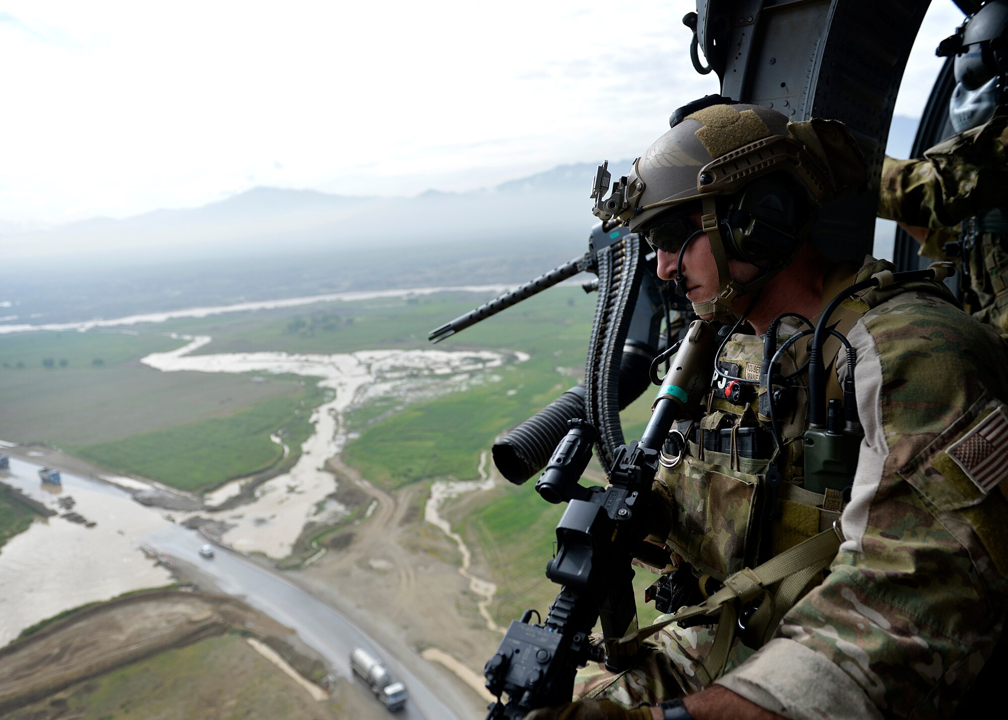 U.S. Air Force Senior Airman Derek Hemerick, 83rd Expeditionary Rescue Squadron, 455 Air Expeditionary Wing pararescueman, watches out the door of an HH-60G Pave Hawk helicopter at Bagram Airfield, Afghanistan May 5, 2014. The squadron participated in a training scenario where a vehicle simulated striking an Improvised Explosive Device.  During the training, rescue crews flew on HH-60G Pave Hawk helicopters to the simulated point of injury, provided security, treated patients, prepared them for travel, and safely departed the area.  Hemerick is a native of San Clemente, Calif. and is deployed from Moody Air Force Base, Ga. (U.S. Air Force photo by Staff Sgt. Evelyn Chavez/Released)
