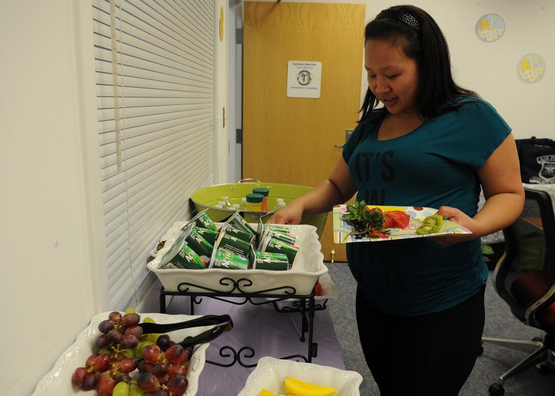Ruby Merjilla picks from an assortment of healthy choices provided to Bundles for Babies attendees May 2, 2014. Bundles for Babies addresses the role of new parents providing guidance and information on nutrition, financial changes and safety concerns. Merjilla and her husband, Senior Airman Nandieboy Merjilla, 779th Medical Group orthopedic technician, are expecting their first child in a few weeks. (U.S. Air Force photo/Staff Sgt. Bahja J. Jones) 