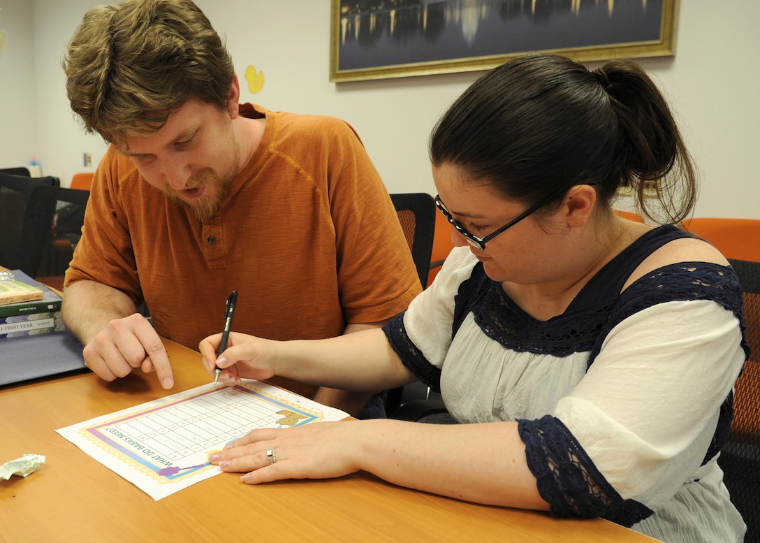 Staff Sgt. Alicia Kruger and husband, Matt Brown, complete a “What do babies need?” activity during a Bundles for Babies workshop at the Military & Family Support Center, May 2, 2014. Bundles for Babies addresses the role of new parents by providing guidance and information on nutrition, financial changes and safety concerns. Kruger is an 89th Communications Squadron system administrator who is expecting her first child. (U.S. Air Force photo/Staff Sgt. Bahja J. Jones) 