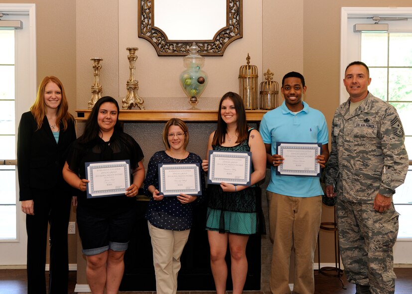 Kamilla Janitell, left, Barksdale Enlisted Spouse Group president, and Chief Master Sgt. Curtis Storms, 2nd Bomb Wing command chief, pose for a photo with scholarship recipients at The Landings on Barksdale Air Force Base, La., May 6, 2014. The BESG selected five scholarship winners based on grade point average and a short essay. (U.S. Air Force photo/Senior Airman Joseph A. Pagán Jr.)