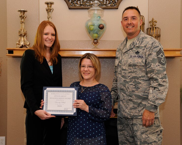 Kamilla Janitell, left, Barksdale Enlisted Spouse Group president, and Chief Master Sgt. Curtis Storms, 2nd Bomb Wing command chief, present Brandy Ollhoff, spouse of Tech. Sgt. Timothy Olhoff, 608th Strategic Operations Squadron, with a scholarship certificate at The Landings on Barksdale Air Force Base, La., May 6, 2014. The BESG raises money throughout the year to award scholarships to enlisted spouses and dependents to help further their educational goals. (U.S. Air Force photo/Senior Airman Joseph A. Pagán Jr.)