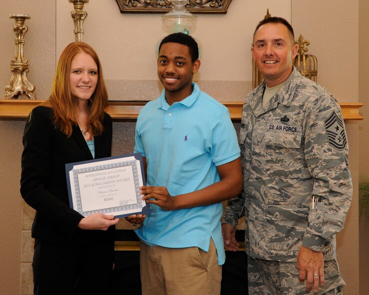 Kamilla Janitell, left, Barksdale Enlisted Spouse Group president, and Chief Master Sgt. Curtis Storms, 2nd Bomb Wing command chief, present Brian Bartee, son of Senior Master Sgt. Emmitt Bartee, 2nd Logistics Readiness Squadron first sergeant, with a scholarship certificate at The Landings on Barksdale Air Force Base, La., May 6, 2014. The BESG raises money throughout the year to award scholarships to enlisted spouses and dependents to help further their educational goals. (U.S. Air Force photo/Senior Airman Joseph A. Pagán Jr.)