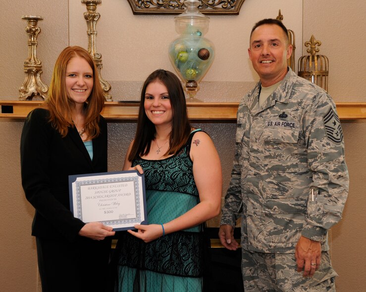 Kamilla Janitell, left, Barksdale Enlisted Spouse Group president, and Chief Master Sgt. Curtis Storms, 2nd Bomb Wing command chief, present Christina Wiley, spouse of Staff Sgt. Cody Wiley, 2nd Civil Engineer Squadron, with a scholarship certificate at The Landings on Barksdale Air Force Base, La., May 6, 2014. The BESG raises money throughout the year to award scholarships to enlisted spouses and dependents to help further their educational goals. (U.S. Air Force photo/Senior Airman Joseph A. Pagán Jr.)