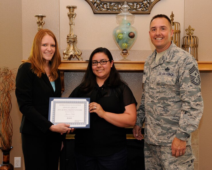 Kamilla Janitell, left, Barksdale Enlisted Spouse Group president, and Chief Master Sgt. Curtis Storms, 2nd Bomb Wing command chief, present Airman 1st Class Shana Neal, 2nd Civil Engineer Squadron pest management, a scholarship certificate on behalf of her spouse Jason Neal at The Landings on Barksdale Air Force Base, La., May 6, 2014. The BESG raises money throughout the year to award scholarships to enlisted spouses and dependents to help further their educational goals. (U.S. Air Force photo/Senior Airman Joseph A. Pagán Jr.)