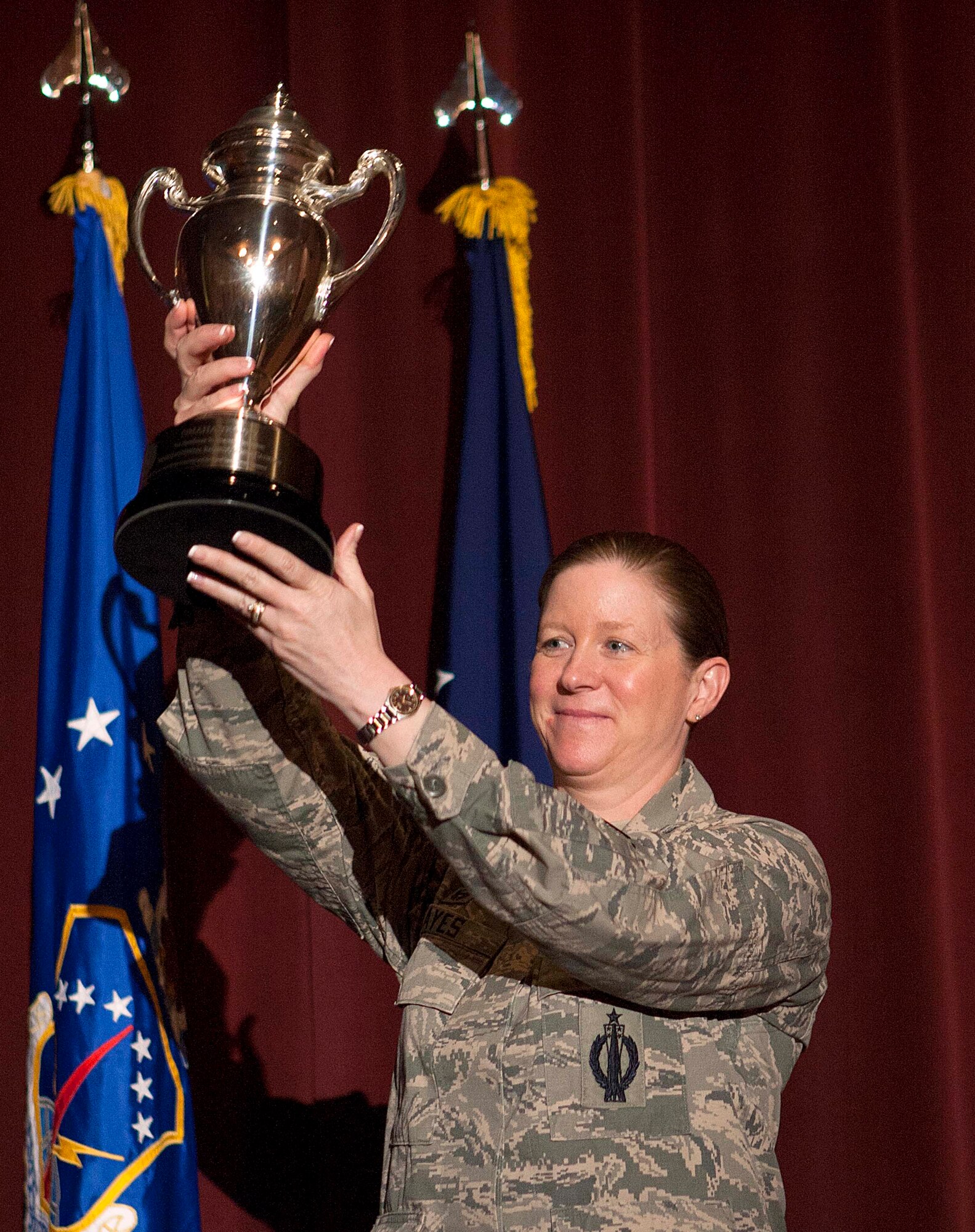 Col. Tracey Hayes, 90th Missile Wing commander, displays the Omaha Trophy to approximately 300 Airmen at the base theater May 6, 2014.  Admiral Cecil Haney, commander of U.S. Strategic Command, presented the award to Hayes and explained the accolades of the Mighty Ninety in 2013, which included two successful missile test launches; overseeing 443 weapon system modifications; and identifying a helicopter fix that was implemented across the other ICBM wings. The Omaha Trophy has been presented annually since 1971 and is awarded to the USSTRATCOM wing that best demonstrates the highest standards of performance based on meritorious achievements, safety, community involvement and humanitarian actions accomplished throughout the previous year. This is the third year in-a-row the Mighty Ninety earned such an award.  (U.S. Air Force photo by R.J. Oriez)