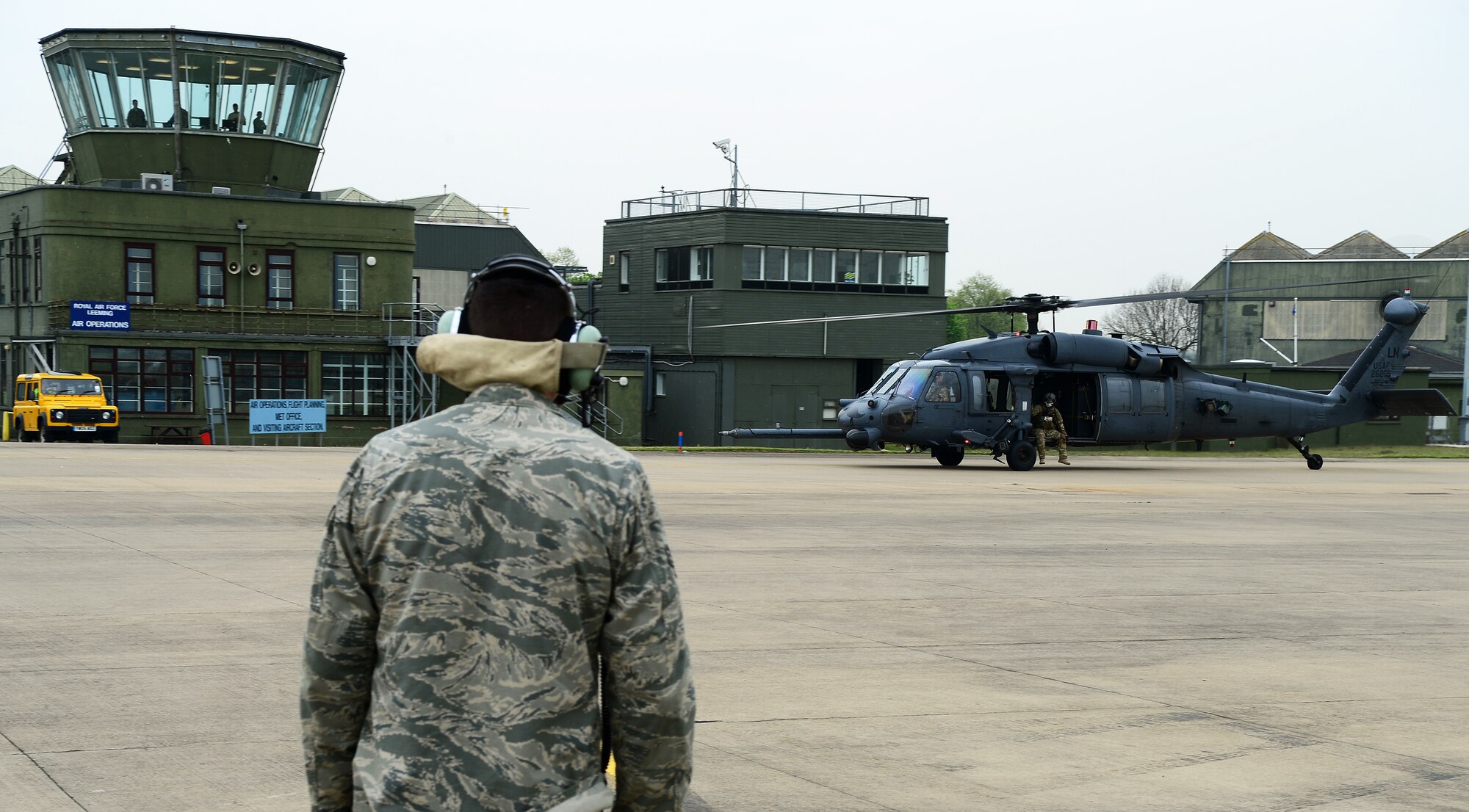 Senior Airman Michael Vest, 748th Aircraft Maintenance Squadron crew chief, waits to marshal and recover an HH-60G Pave Hawk at Royal Air Force Leeming, England, April 30, 2014. Pilots trained to evade radar threats while performing search-and-rescue missions during the week-long training event. (U.S. Air Force photo by Staff Sgt. Emerson Nuñez/Released)