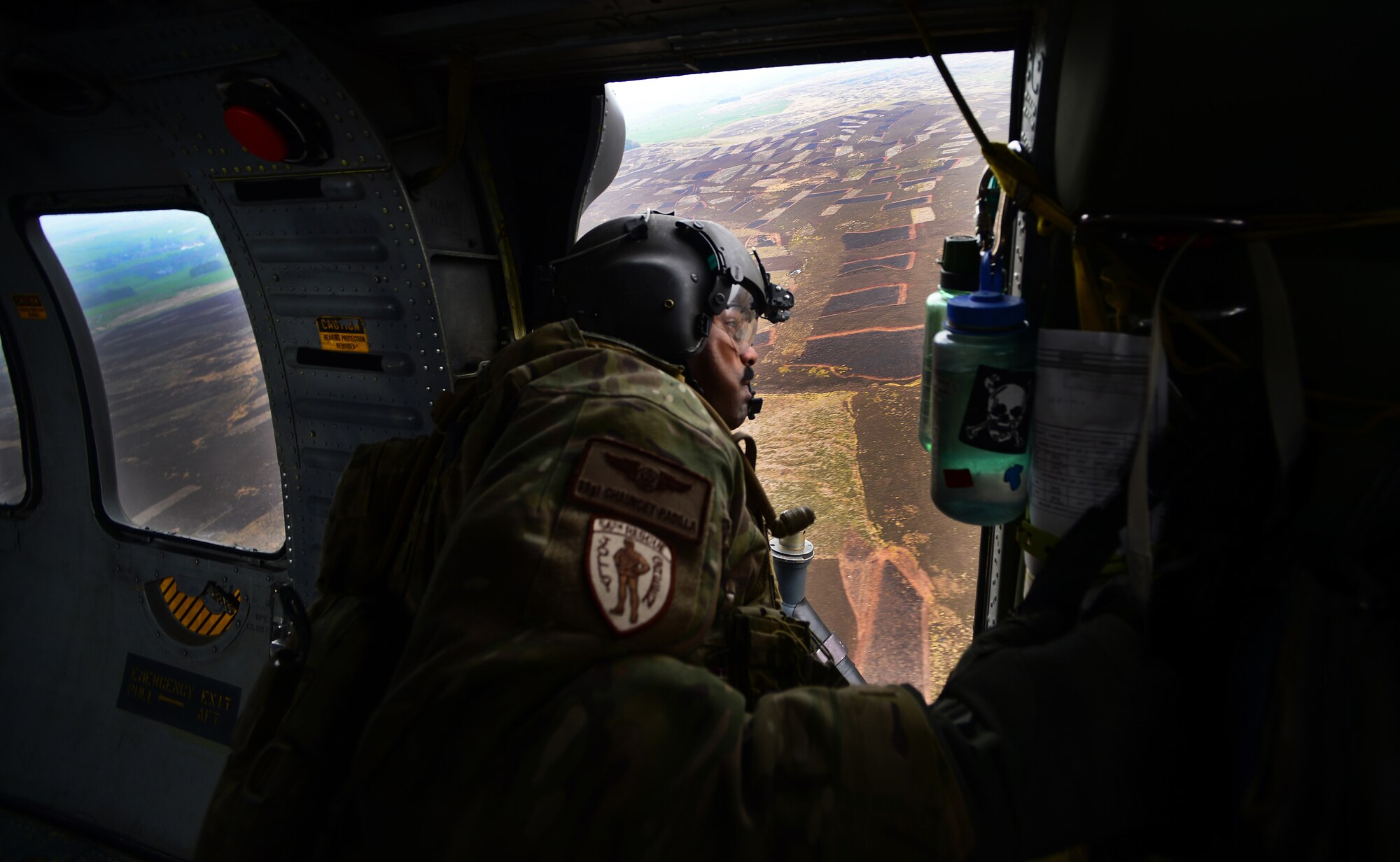 Staff Sgt. Chauncey Padilla, 56th Rescue Squadron special mission aviator, scans the terrain outside an HH-60G Pave Hawk after its return flight to Royal Air Force Leeming, England, April 29, 2014. The 56th RQS spent a week at RAFs Leeming and Spadeadam training to survive, deny and defeat radar threats. (U.S. Air Force photo by Staff Sgt. Emerson Nuñez/Released)