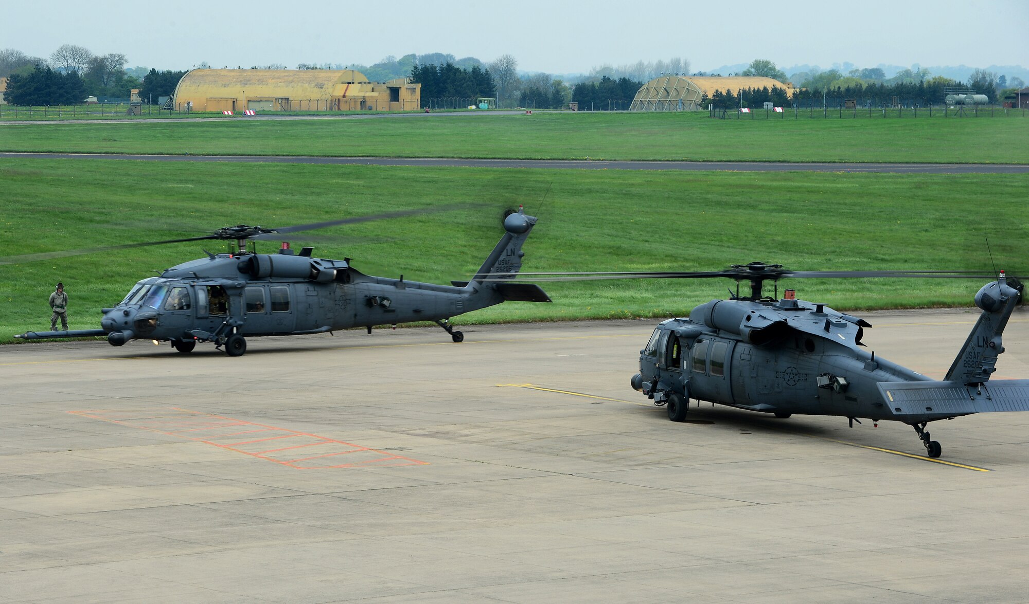 Two HH-60G Pave Hawks assigned to the 56th Rescue Squadron taxi down the flightline at Royal Air Force Leeming, England, April 30, 2014. Pilots were trained on evading radar threats in order to gain experience outside of a computer simulation during the week-long training event. (U.S. Air Force photo by Staff Sgt. Emerson Nuñez/Released)