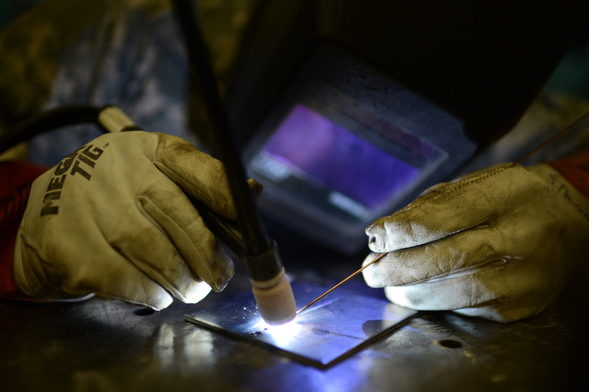 U.S. Air Force Staff Sgt. Steven Doucette, 52nd Equipment Maintenance Squadron metals technology technician from Beaumont, Calif., welds two metal sheets together inside the fabrication flight shop at Spangdahlem Air Base, Germany, May 6, 2014. Doucette controls the 400 amp welder with a foot petal, which allows his hands freedom of movement. (U.S. Air Force photo by Senior Airman Gustavo Castillo/Released) 