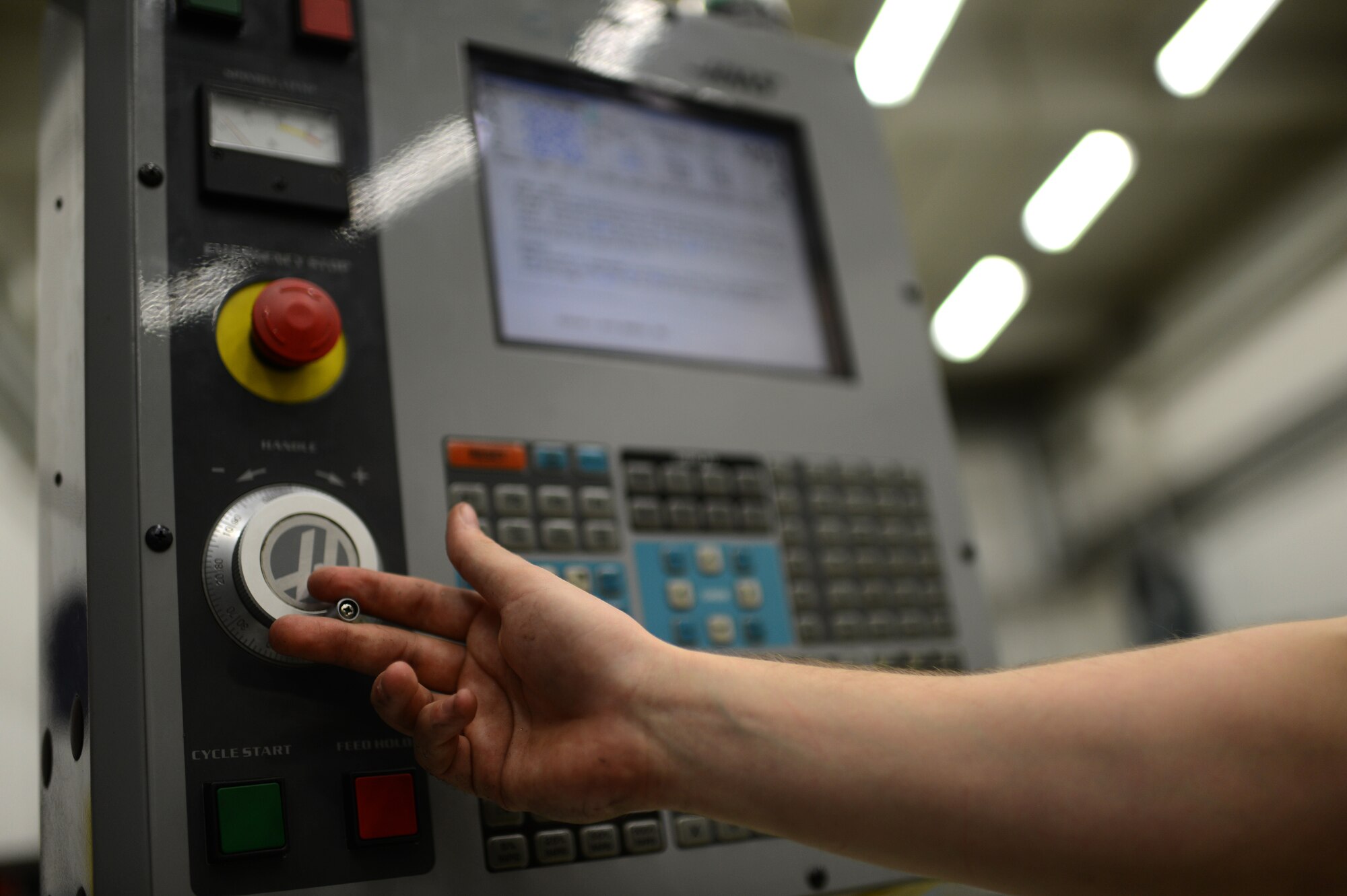 U.S. Air Force Airman Alex Larkin, 52nd Equipment Maintenance Squadron aircraft metals technician from Queen Creek, Ariz., adjusts the movement of a mill inside the fabrication flight shop at Spangdahlem Air Base, Germany, May 6, 2014. The computer system attached to the mill allows Larkin to make accurate measurements while cutting or drilling into metal that can be used for anything from aircraft parts to tire racks. (U.S. Air Force photo by Senior Airman Gustavo Castillo/Released)