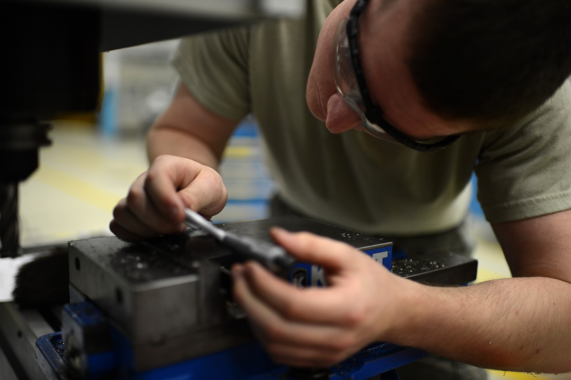U.S. Air Force Airman Alex Larkin, 52nd Equipment Maintenance Squadron aircraft metals technician from Queen Creek, Ariz., measures the width of a piece of metal inside the fabrication flight shop at Spangdahlem Air Base, Germany, May 6, 2014. Creation of mechanical parts from scratch requires precise measurements to ensure proper functionality. (U.S. Air Force photo by Senior Airman Gustavo Castillo/Released) 