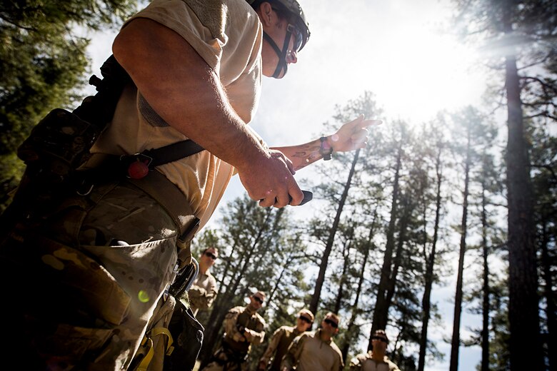 A U.S. Air Force pararescueman from the 58th Rescue Squadron out of Nellis Air Force Base, Nev., discusses tree let-down procedures May 5, 2014, at Camp Navajo, Ariz., in part of Angel Thunder. Angel Thunder is the largest and most realistic joint service, multinational, interagency combat search and rescue exercise designed to provide training for personnel recovery assets. (U.S. Air Force photo by Staff. Sgt. Jamal D. Sutter/Released)    