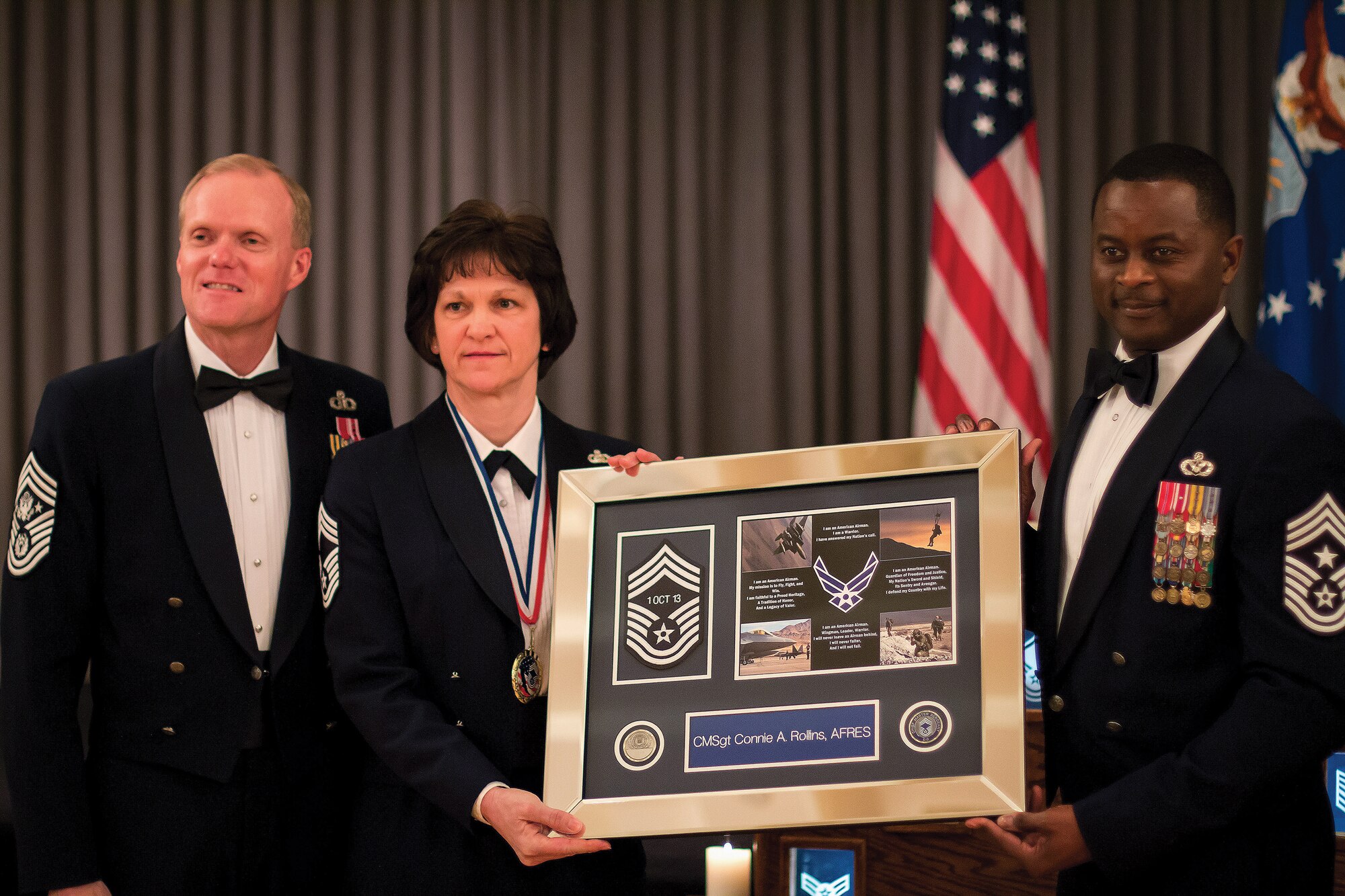As Chief Master Sergeant of the Air Force James Cody stands by,  42nd ABW Command Chief Master Sgt. Harry Hutchinson makes a presentation to Chief Master Sgt. Connie Rollins of the 908th LRS.