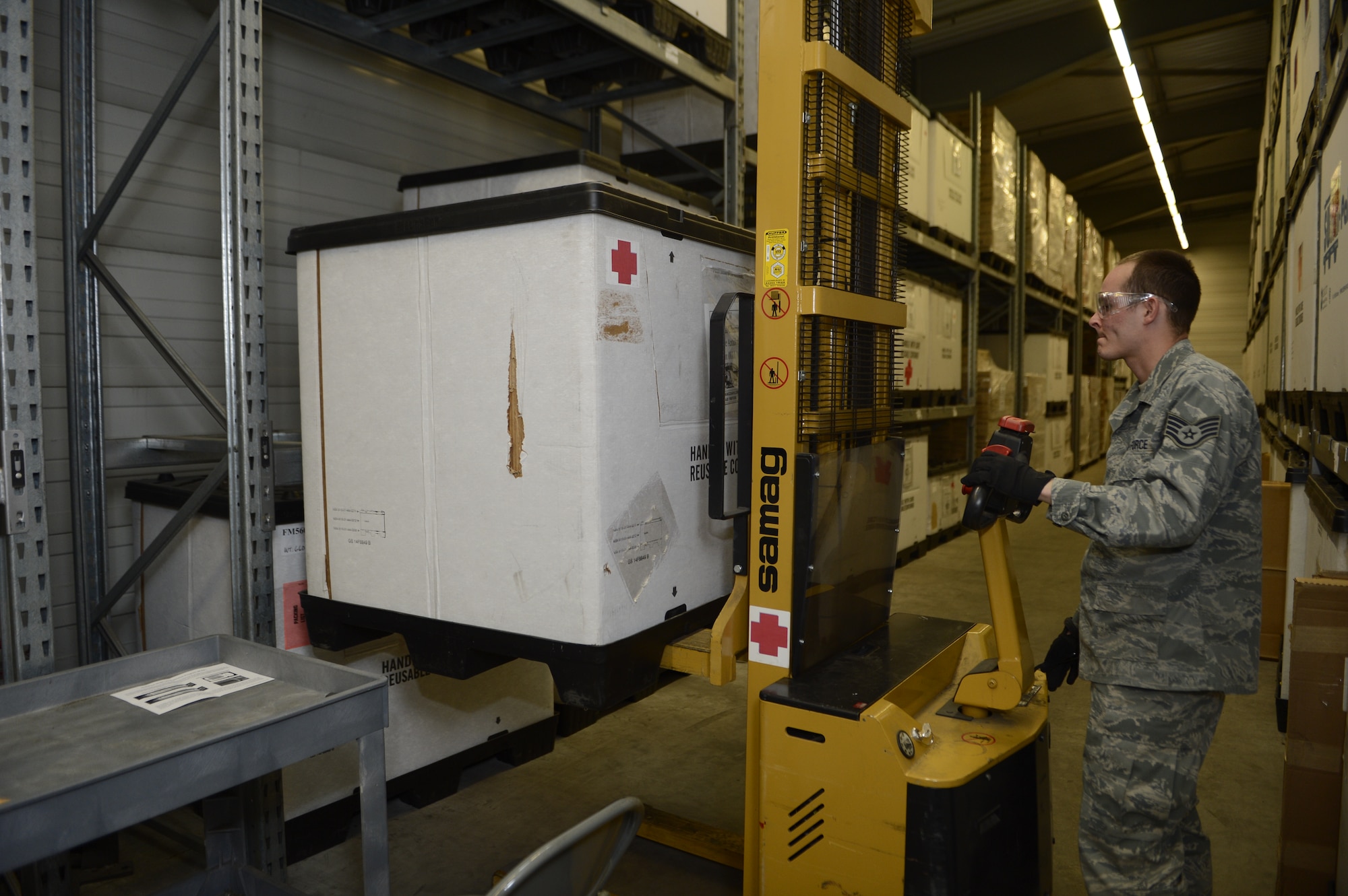 U.S. Air Force Staff Sgt. James Bishop, 52nd Medical Support Squadron medical logistics technician from Fort Worth, Texas, uses a forklift to handle medical storage containers at the 52nd MDSS warehouse in Zemmer, Germany, May 5, 2014. Most medical supplies used by the Spangdahlem Air Base Clinic are delivered here before distribution. (U.S. Air Force photo by Staff Sgt. Christopher Ruano/Released)