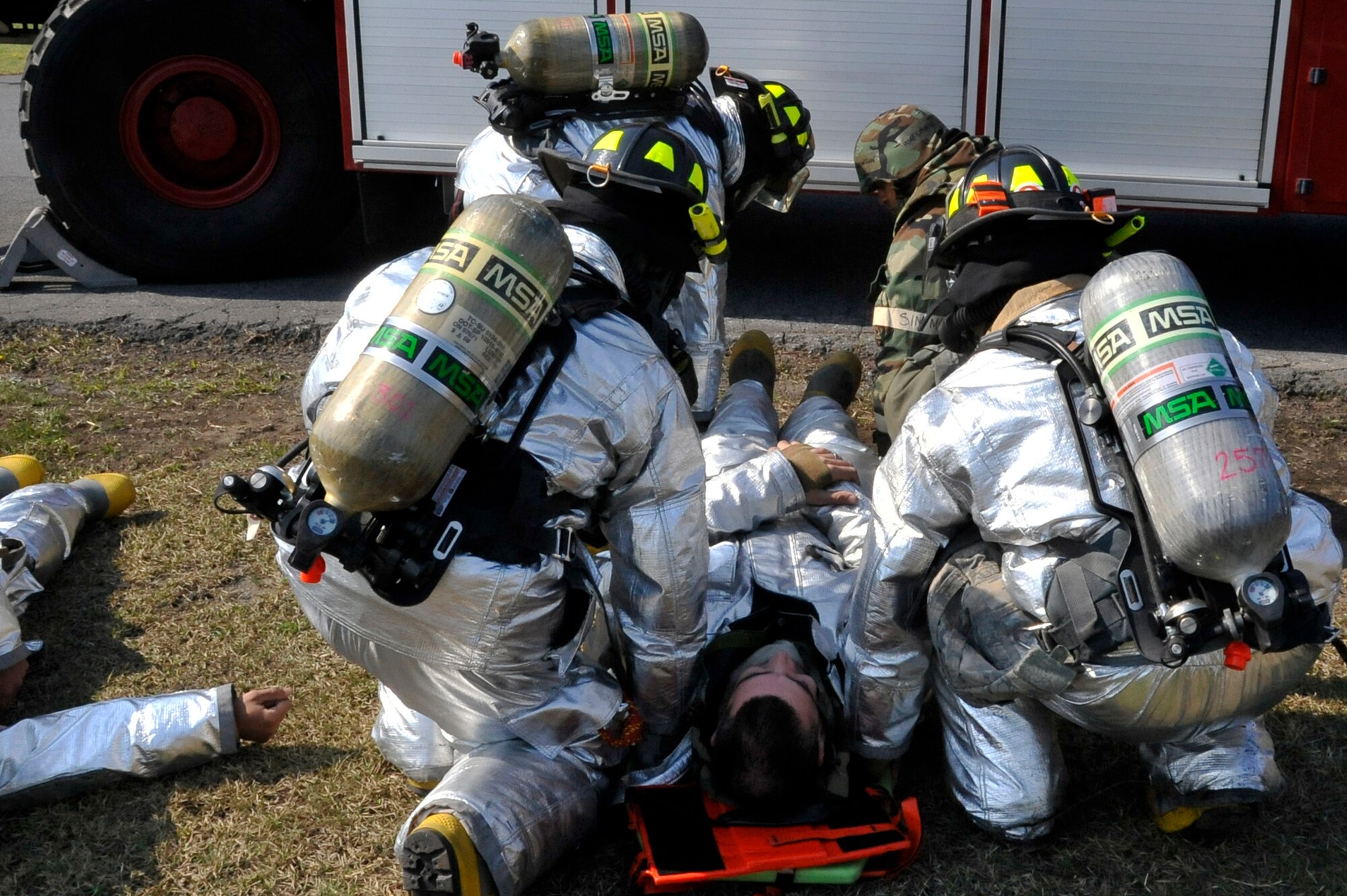 Members of the 35th Civil Engineer Squadron fire department transport a simulated fallen comrade after a fuel explosion during Phase II of an Operational Readiness Exercise at Misawa Air Base, Japan, May 7, 2014. These exercise situations train Airmen to sharpen their life saving skills for real-world emergencies. (U.S. Air Force photo/Airman 1st Class Patrick Ciccarone)