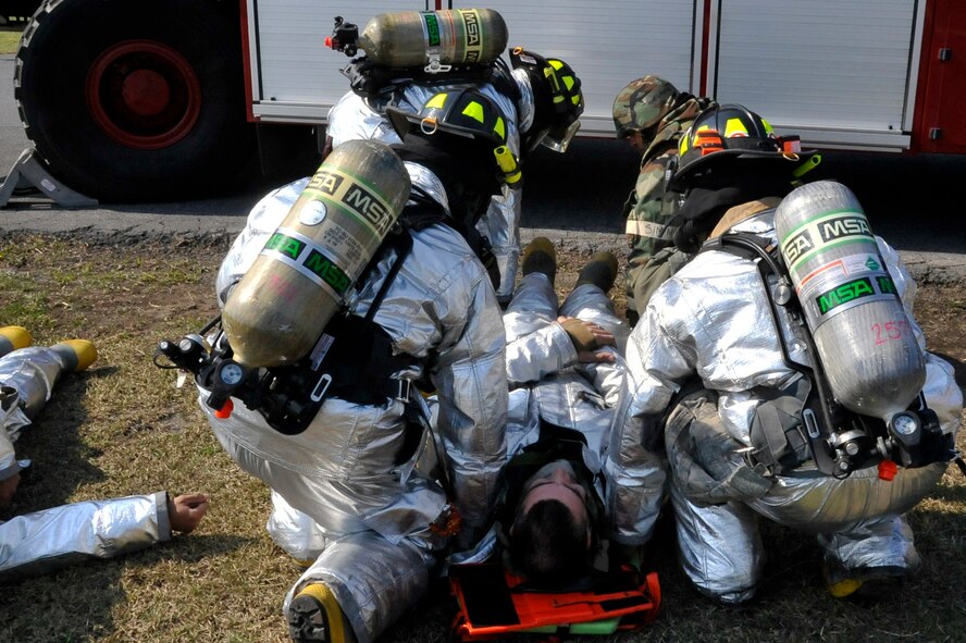 Members of the 35th Civil Engineer Squadron fire department transport a simulated fallen comrade after a fuel explosion during Phase II of an Operational Readiness Exercise at Misawa Air Base, Japan, May 7, 2014. These exercise situations train Airmen to sharpen their life saving skills for real-world emergencies. (U.S. Air Force photo/Airman 1st Class Patrick Ciccarone)