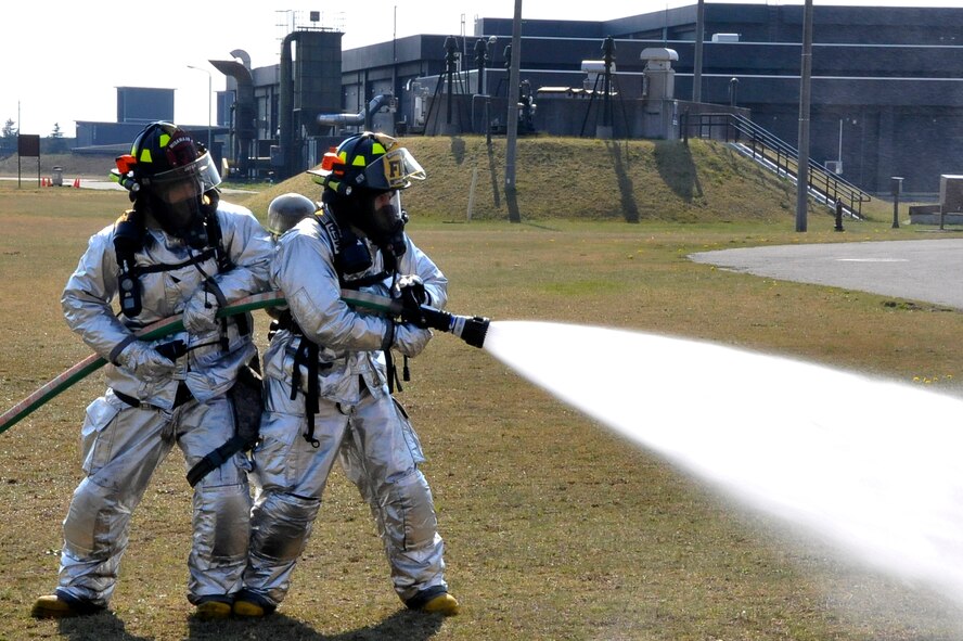 Firefighters from the 35th Civil Engineer Squadron utilize their high pressure water hose and fight a fire created from a simulated fuel leak during Phase II of an Operational Readiness Exercise at Misawa Air Base, Japan, May 7, 2014. The simulated fire was a result of an ORE scenario that involved over 600 gallons of fuel leaking from a nearby tanker truck. (U.S. Air Force photo/Airman 1st Class Patrick Ciccarone)
