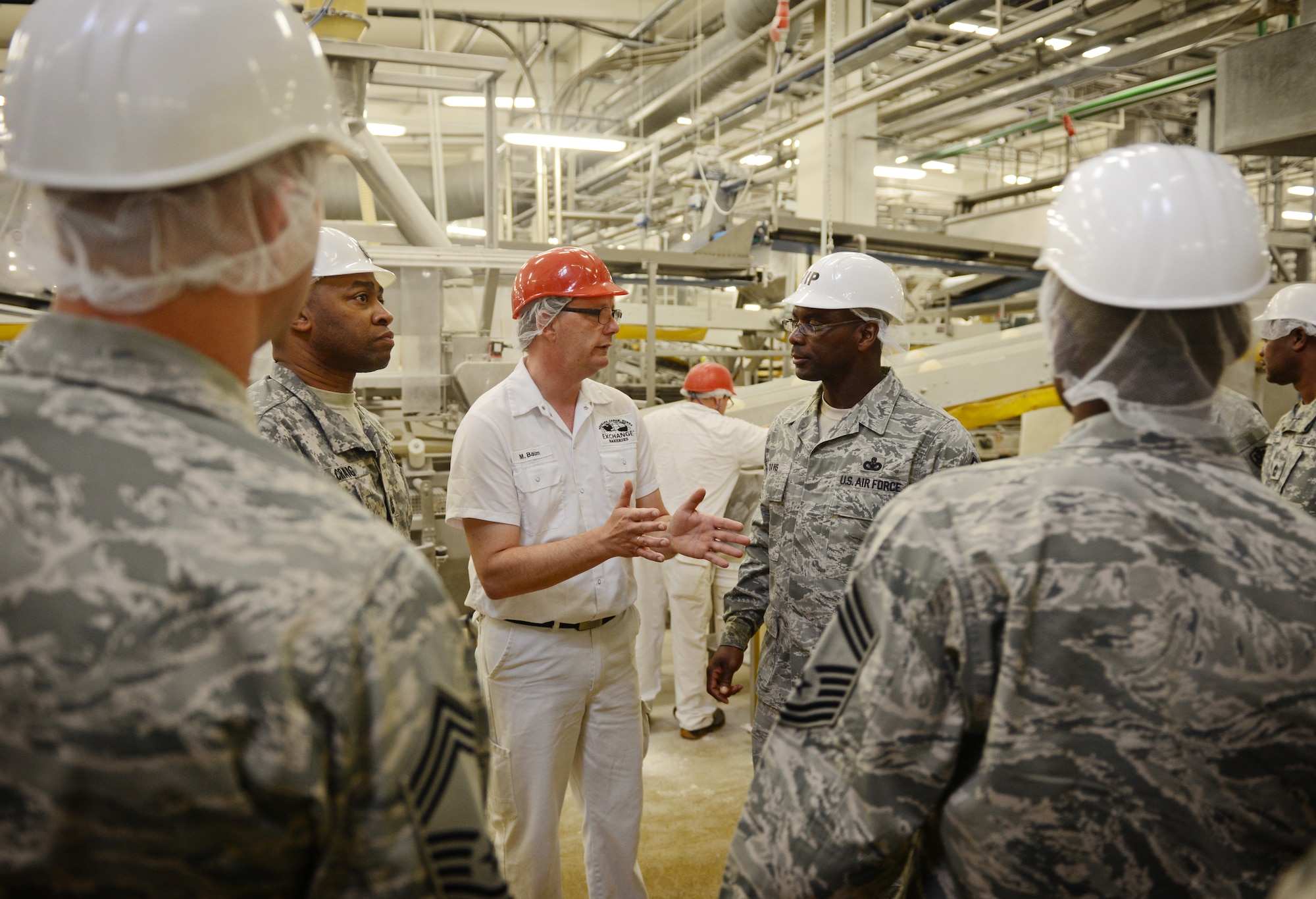 Mathias Baum, Army and Air Forces Exchange Service bakery manager, speaks to Chief Master Sgt. James E. Davis, U.S. Air Forces Europe and Air Forces Africa command chief, during a familiarization tour in Gruenstadt, Germany, April 30, 2014. The Gruenstadt facility is the central production location for more than 250 line items, as well as cold storage for 200 line items and even produces five million gallons of Culligan bottled water each year. The plant distributes to more than 100 locations in 25 countries and has been in business since 1953. (U.S. Air Force photo/ Staff Sgt. Ryan Crane)
