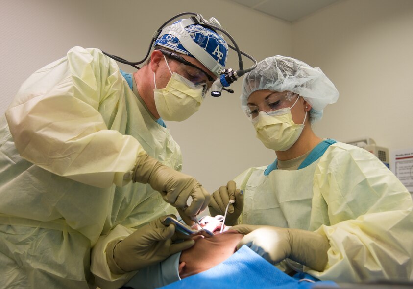 Maj. Curtis Hayes (left), 86th Dental Squadron chief oral and maxillofacial surgeon, and Senior Airman Britanni McKnight, 86th DS dental assistant, operate on a patient during a dental implant surgery at Ramstein Air Base, April 29, 2014, Germany. Standing out from thousands of dental Airmen around the world Hayes was named Air Force Dentist of the Year for his outstanding accomplishments. (U.S. Air force photo/Senior Airman Jonathan Stefanko)