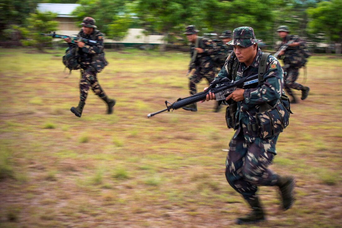 Philippine Army Cpl. Kenneth Dumagco, foreground, moves to a notional extract location during helicopter insert and extract training with U.S. soldiers on Fort Magsaysay, Philippines, April 29, 2014.