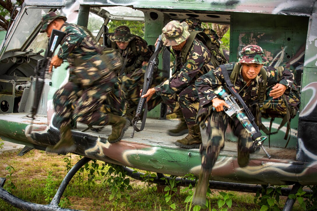 Philippine soldiers exit a grounded training helicopter during helicopter insert and extract training with U.S. soldiers on Fort Magsaysay, Philippines, April 29, 2014.
