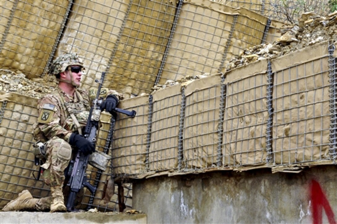 A U.S. soldier takes a knee at his post during a mission to provide security for a U.S. and Afghan forces security meeting in the Chamkani district of Afghanistan's Paktia province, May 4, 2014. The soldiers are assigned to the 10th Mountain Division's 71st Cavalry Regiment, 3rd Brigade Combat Team. 