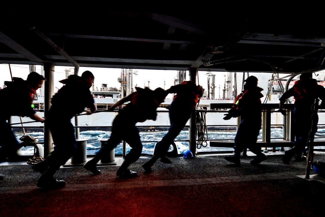 U.S. Navy sailors walk a line during a replenishment with the Military Sealift Command fleet replenishment oiler ship USNS Tippecanoe in the Arabian Gulf, Aug. 24, 2013. The sailors are assigned to the guided-missile cruiser USS Monterey, which is supporting support of maritime security operations and theater security cooperation efforts in the U.S. 5th Fleet area of responsibility.  
