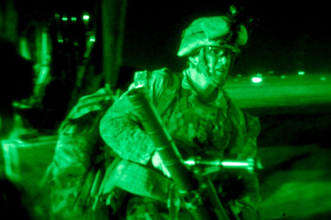 As seen through a night-vision device, U.S. Marines and Afghan forces exit a CH-53E Super Stallion helicopter after completing an air interdiction exercise on Camp Bastion in Helmand province, Afghanistan, Aug. 20, 2013.  
