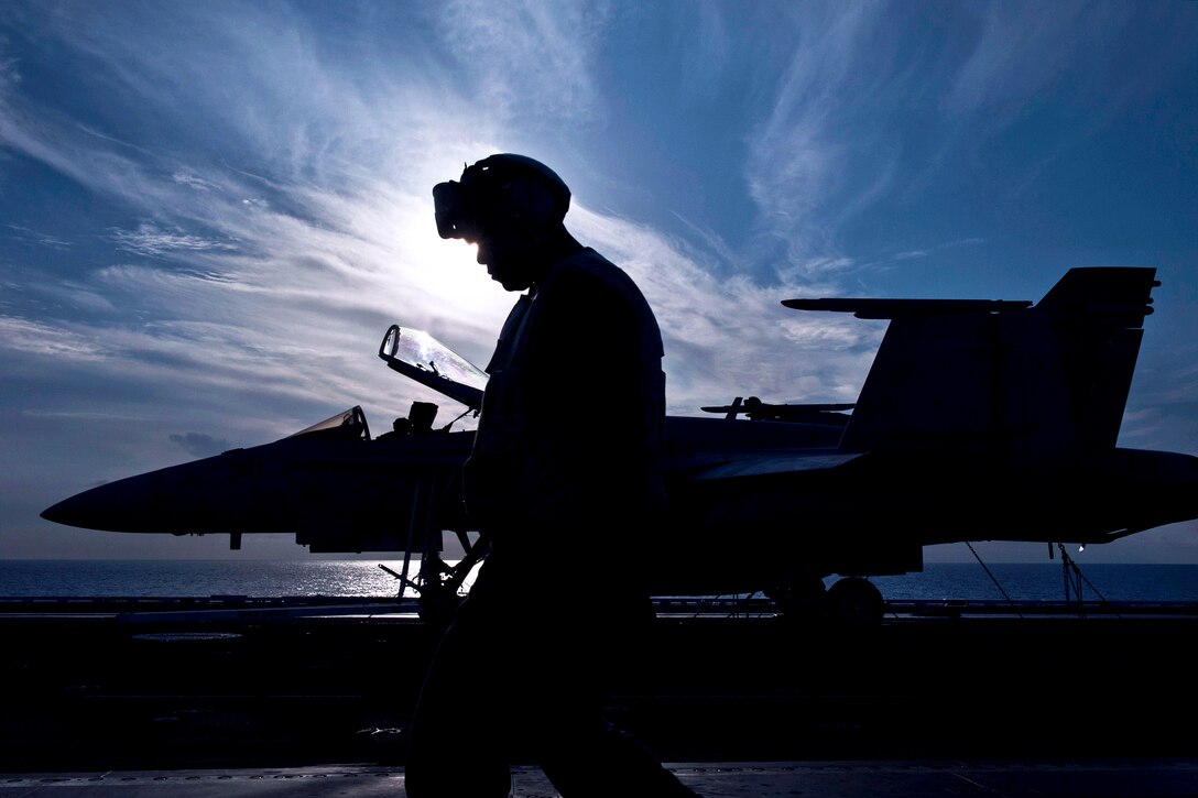 U.S. Navy Petty Officer 3rd Class Jason George stands watch on the flight deck of the aircraft USS George H.W. Bush in the Atlantic Ocean, Aug. 15, 2013. George, an aviation structural mechanic, is assigned to Strike Fighter Squadron 31.  
