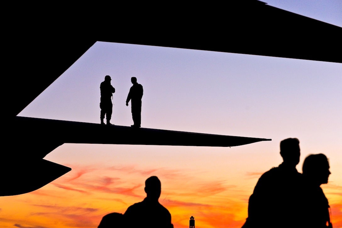 Air Force Master Sgt. Robin Wright, top left, and Air Force Tech. Sgt. Flint Hamilton, top right, visually inspect the wing of a C-130 Hercules aircraft as airmen off-load to support exercise Global Medic 2013 at Pittsburgh International Airport Air Reserve Station in Coraopolis, Pa., July 29, 2013. Wright, a crew chief, is assigned to the 440th Aircraft Maintenance Squadron, and Hamilton, a flight engineer, is assigned to the 95th Airlift Squadron.  
