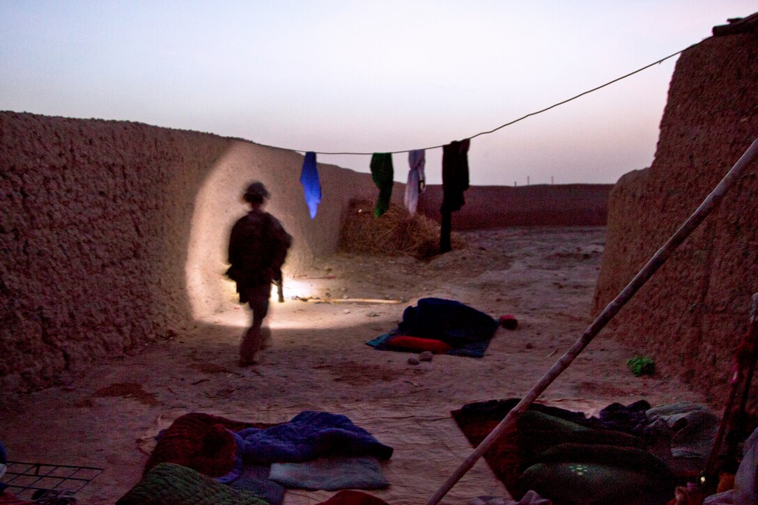 U.S. Marine Corps Lance Cpl. John J. McConnell searches outside an Afghan compound for weapons during Operation Grizzly in Helmand province, Afghanistan, July 18, 2013. McConnell is assigned to Fox Company, 2nd Battalion, 2nd Marine Regiment. 