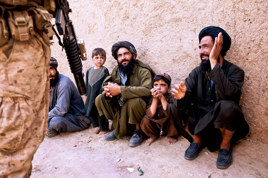 U.S. Marine Corps Cpl. Andrew Crisp, left, talks with Afghan villagers during Operation Grizzly in Helmand province, Afghanistan, July 18, 2013. Crisp is assigned to Fox Company, 2nd Battalion, 2nd Marine Regiment.  
