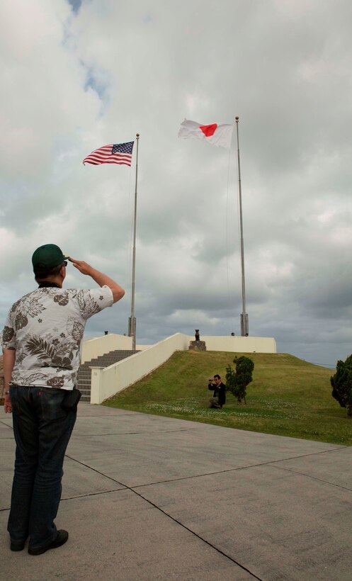 An Okinawa citizen salutes the national ensigns of the U.S. and Japan April 29 at Camp Foster, during a community outreach event called the Marine Corps 101 Seminar. The event allows Okinawa citizens the opportunity to learn the history of the U.S. Marine Corps and see military life on various installations. 