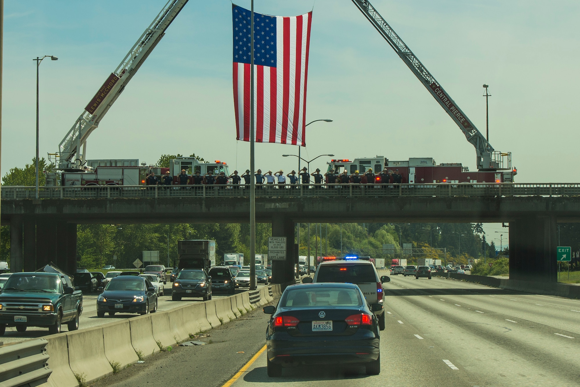 Central Pierce and Joint Base Lewis-McChord firefighters salute the procession of Capt. Douglas D. Ferguson's remains May 1, 2014, on an overpass in Tacoma, Wash. Ferguson, a Tacoma native, was killed while on a reconnaissance mission over Laos when his aircraft was shot down Dec. 30, 1969. (U.S. Air Force photo/Tech. Sgt. Sean Tobin)