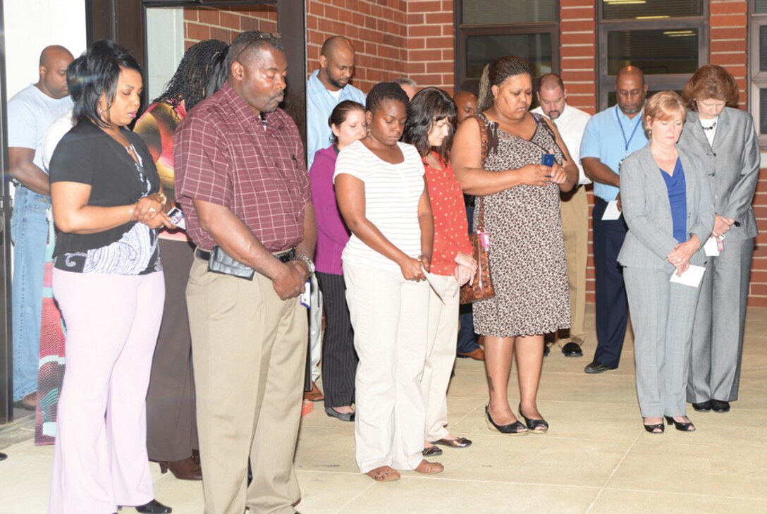 Base employees pray silently during the National Day of Prayer ceremony in front of Coffman Hall, May 1, 2014.