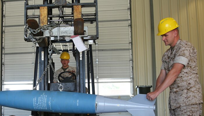 Sgt. Jason Connolly (right), an aviation ordnance systems technician with Marine Aviation Logistics Squadron 14, moves a 500 pound bomb body from a palate to a cradle May 5, at Marine Corps Air Station Cherry Point. Connolly recently won the Marine Corps Aviation Association’s ordnance Marine of the Year Award and the East Coast Aviation Ordnance Man of the Year Award. Connolly attributed his success to his peers and his leadership.