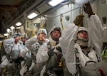 Army Maj. Aaron Williams (right), 2nd Engineer Brigade, 6th Engineer Battalion (Combat)(Heavy), battalion executive officer, secures his static line to his parachute before jumping out of a C-17 Globemaster III during Arctic Pegasus, May 1, 2014. Arctic Pegasus is a multi-component, joint exercise that will further refine planning and mission capabilities between U.S. Army Alaska, the U.S. Air Force, the Alaska National Guard, and the state of Alaska. (U.S. Air Force photo/Staff Sgt. Zachary Wolf)