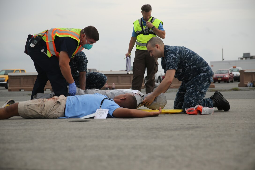 Emergency personnel tend to simulated victims April 29, during a mass casualty exercise aboard Marine Corps Air Station Cherry Point. The exercise tested how fast first responders, Cherry Point personnel and civilian personnel were able to respond to a mock aircraft mishap in which a number of air show participants were "injured" and required assistance. 