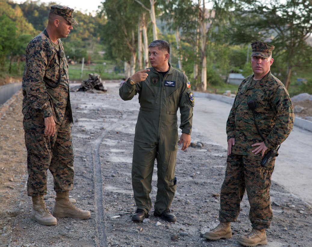 Philippine Air Force Lt. Col. Romell Allan P. Genete, center, the group commander of the 790th Air Base Group, discusses road construction operations with U.S. Marine Corps Chief Warrant Officer 3 Keith W. Earhart, right, and U. S. Marine Corps Master Sgt. Mark D. McLaughlin, left, May 4, 2014, at Crow Valley, Philippines. The Philippine Air Force will team up with U.S. Marines to help relieve traffic hazards outside a major training area of Balikatan 2014. The two nation’s militaries will participate in the exercise to increase interoperability and reinforce mission readiness. Earhart and McLaughlin are assigned to 3rd Maintenance Battalion, Combat Logistics Regiment 35, 3rd Marine Logistics Group, III Marine Expeditionary Force.